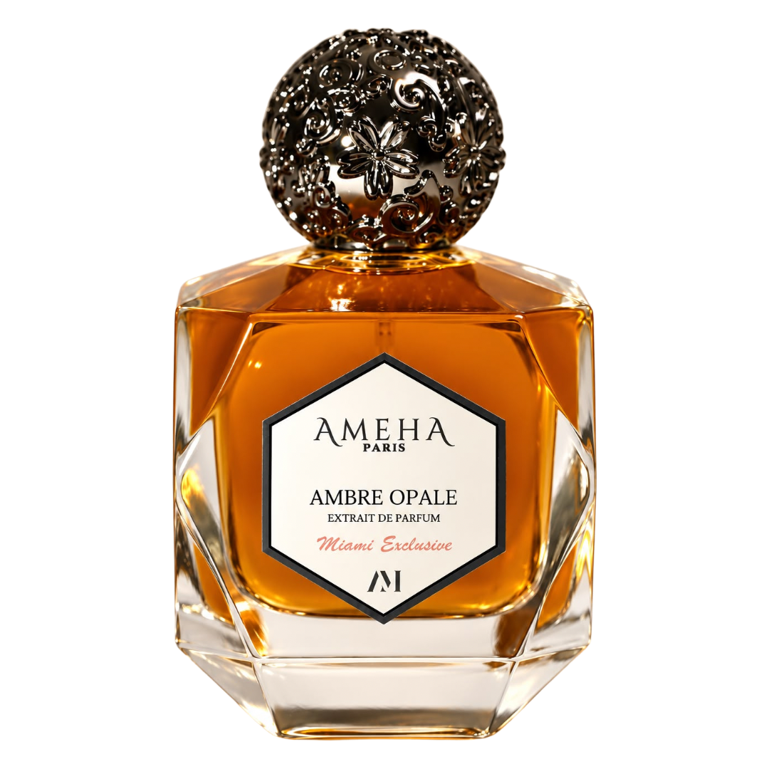A faceted glass perfume bottle filled with amber liquid, featuring a silver ornate cap and a white hexagonal label reading 'AMEHA PARIS AMBRE OPALE'.