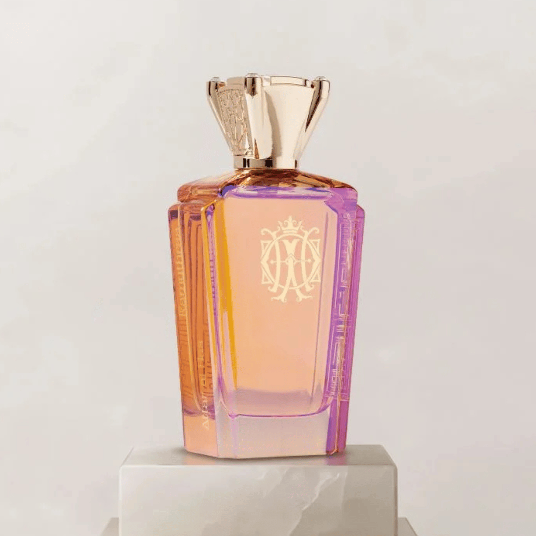 Perfume bottle with gold cap and decorative label on a light gray background