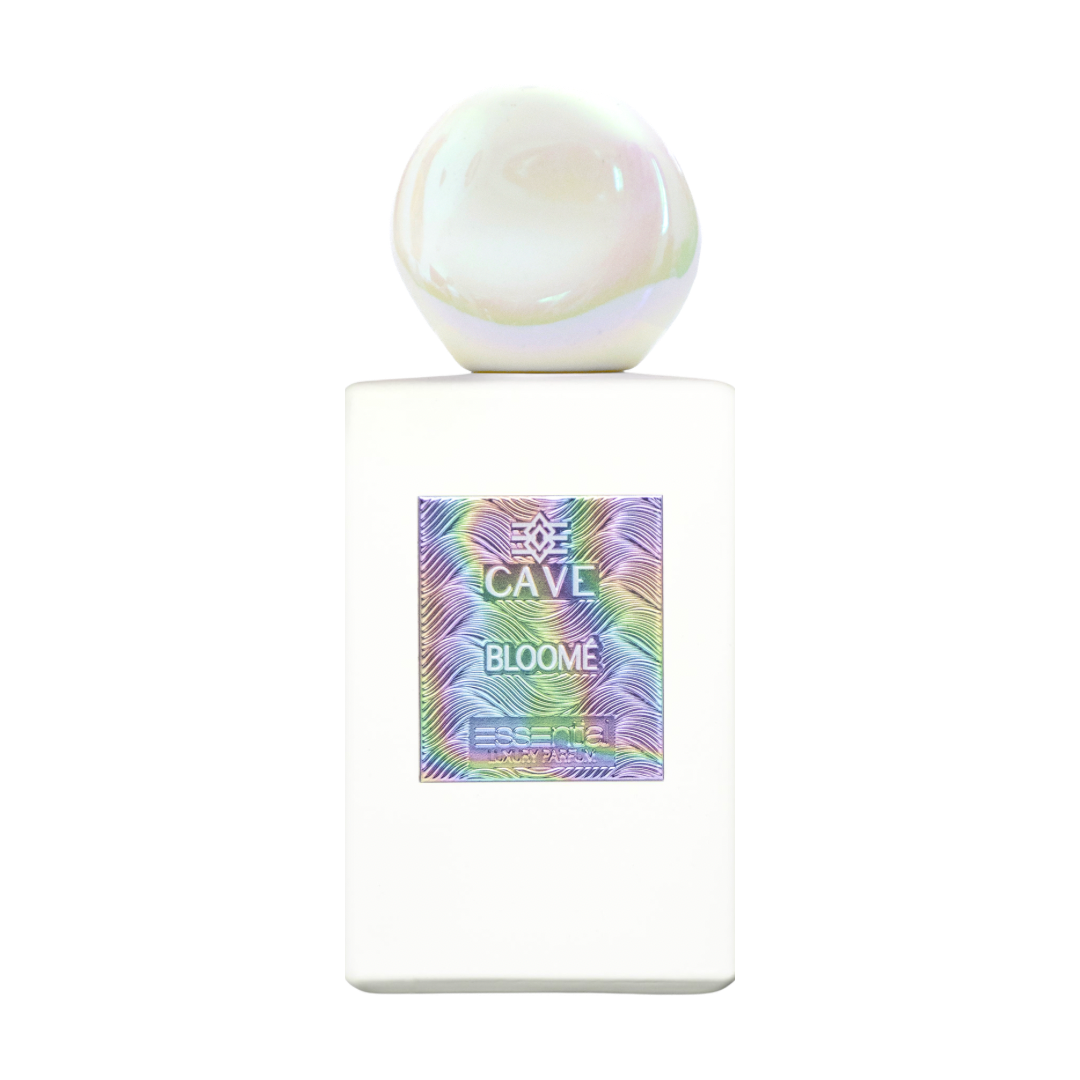 A white rectangular bottle with a spherical, iridescent white cap, featuring a colorful holographic label that reads 'CAVE BLOOME' and 'ESSENCE BLOOM'.