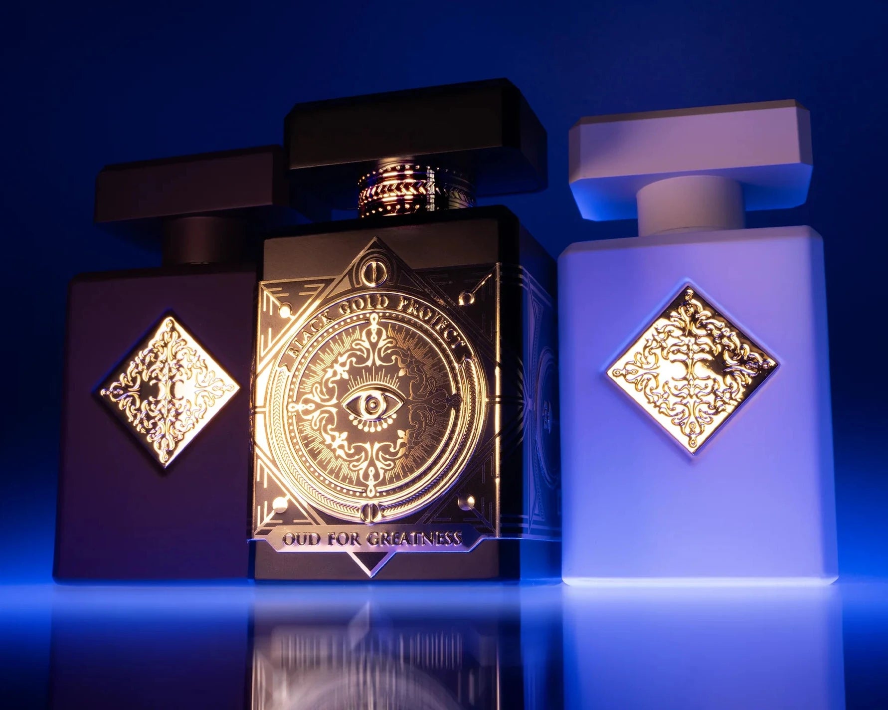 Two perfume bottles with decorative labels on a reflective surface with a blue gradient background