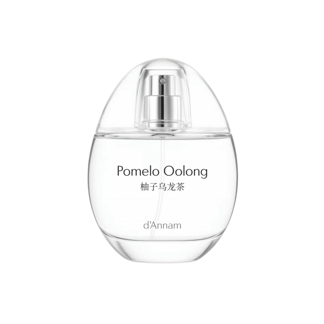 Clear perfume bottle labeled 'Pomelo Oolong' by d'Annam on a green background