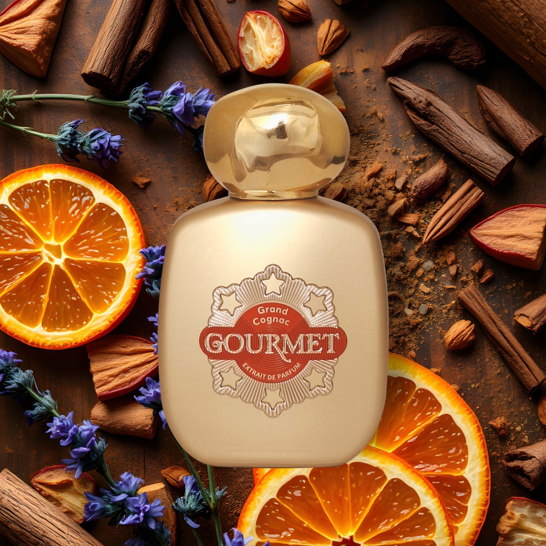 Gourmet perfume bottle surrounded by oranges, cinnamon sticks, and lavender on a wooden surface