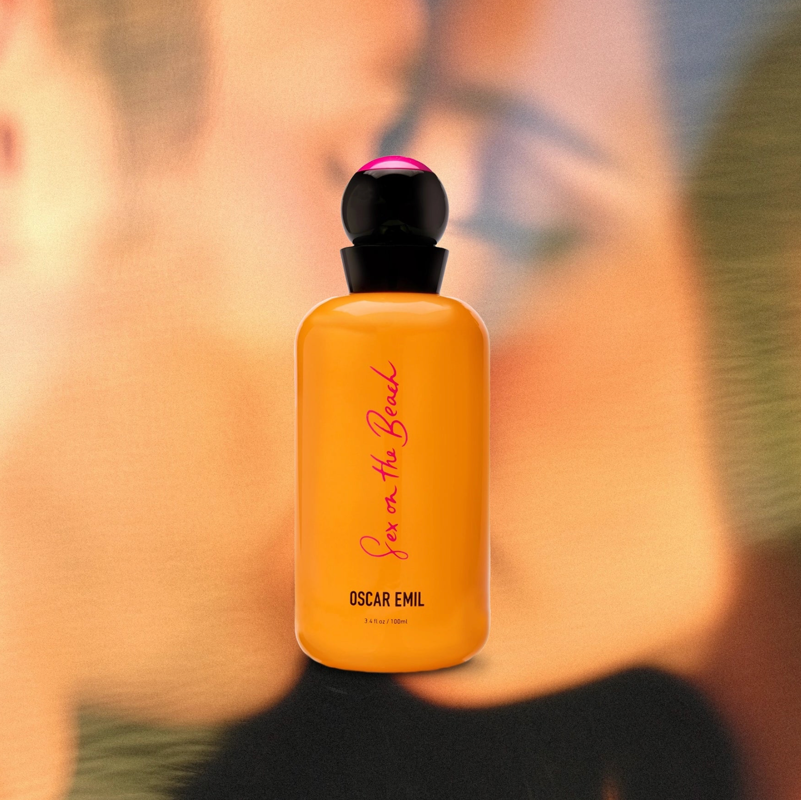 Orange perfume bottle with black cap and visible branding on a blurred background