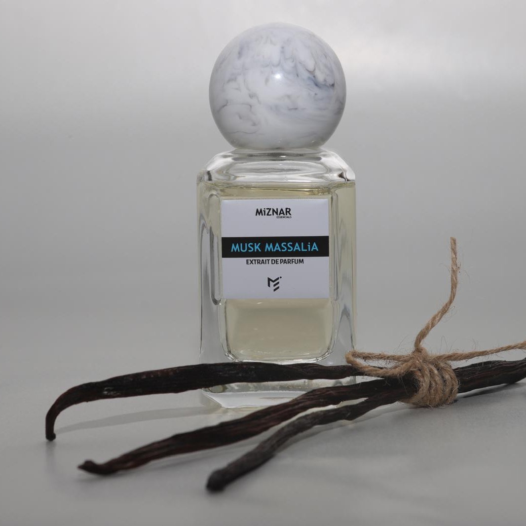 Perfume bottle labeled 'Miznar' with vanilla beans on a gray background