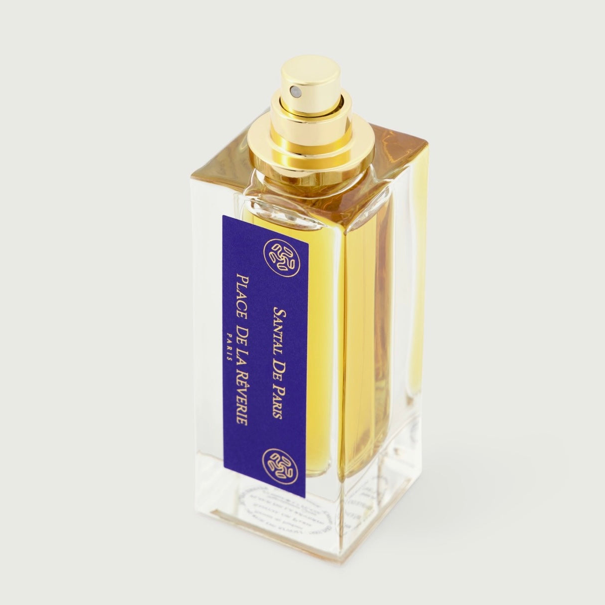 Perfume bottle with gold cap and blue label on a white background