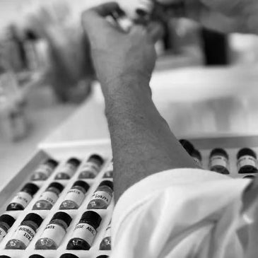 Person organizing bottles on a shelf with a blurred background