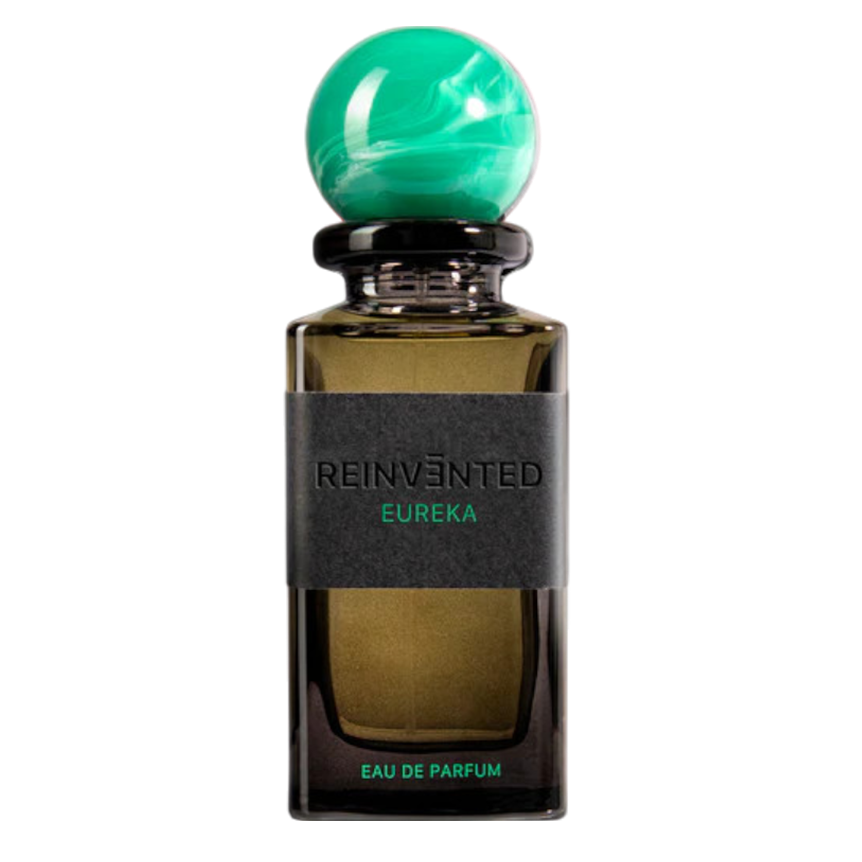 A bottle of REINVÄNTED EUREKA Eau de Parfum with a green cap, black label, and a teal ball on top. The text on the label reads 'Eau de Parfum' and the brand name 'Reinvented'.