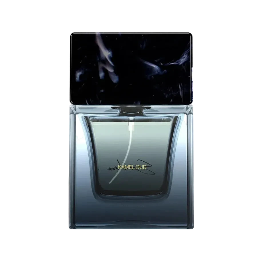 A rectangular glass perfume bottle with a dark smoky gradient interior and a black cap featuring an abstract smoky pattern. A blue and black signature is printed on the front of the bottle.