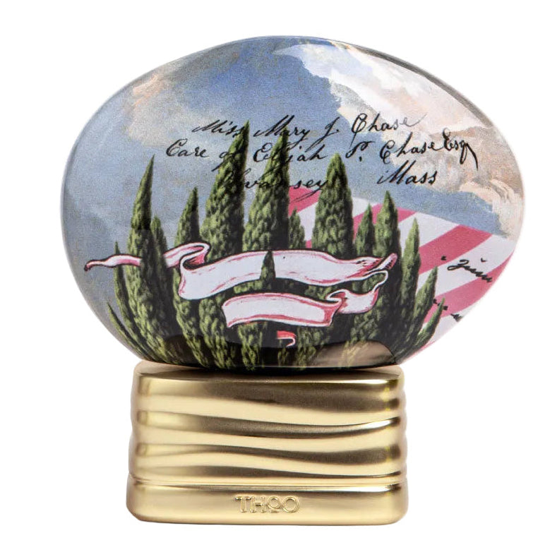 Decorative paperweight with scenic design and gold base on a white background
