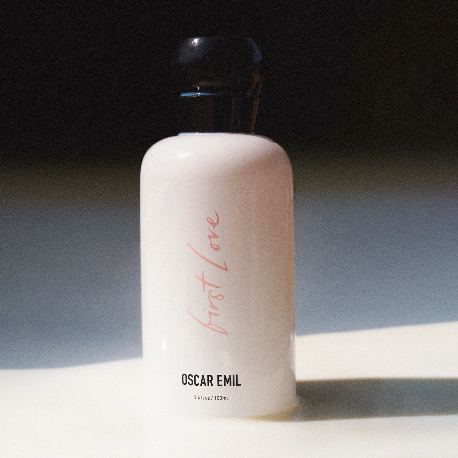 White bottle labeled 'First Love' by Oscar Emil on a dark background