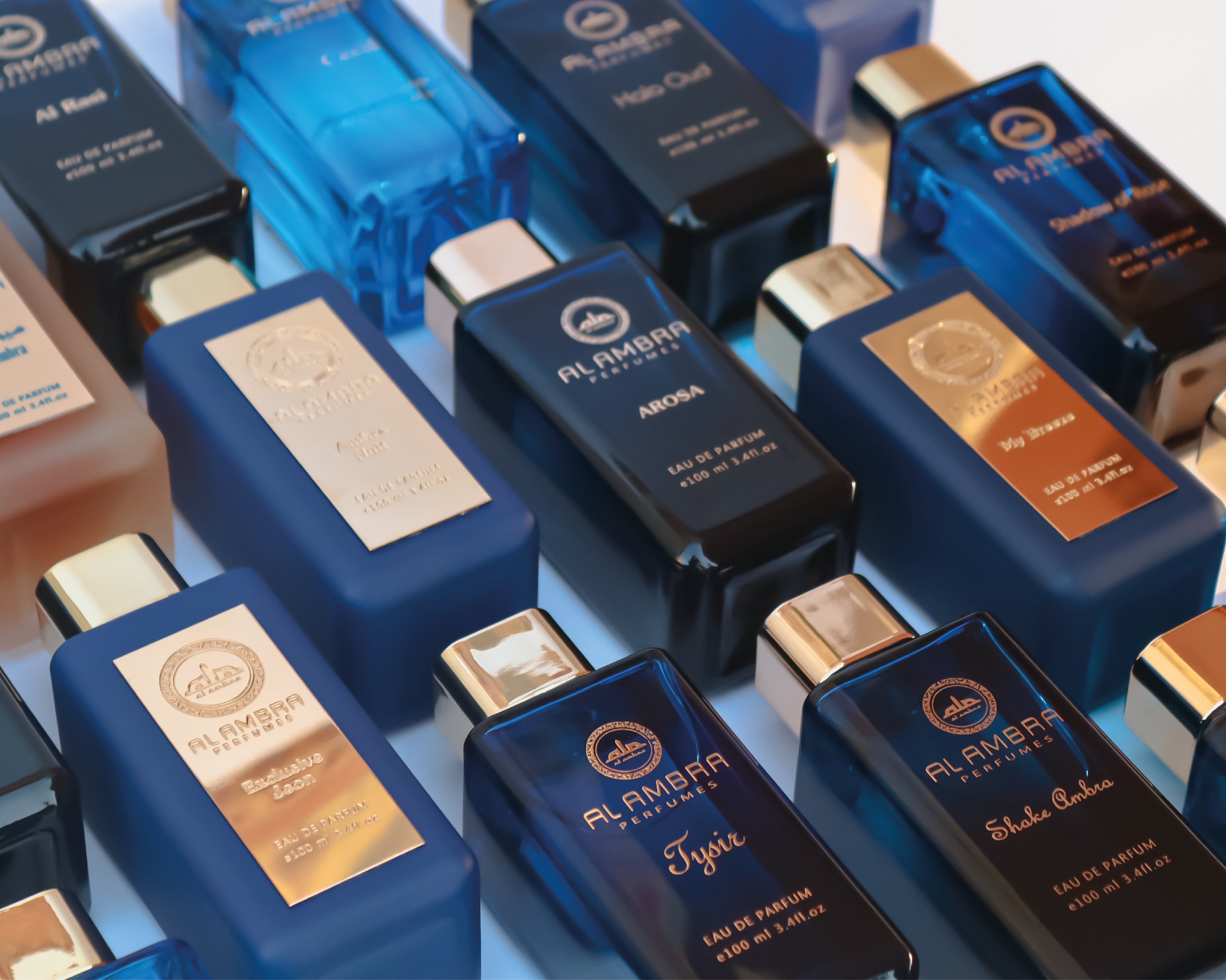 Collection of blue perfume bottles with visible labels on a reflective surface