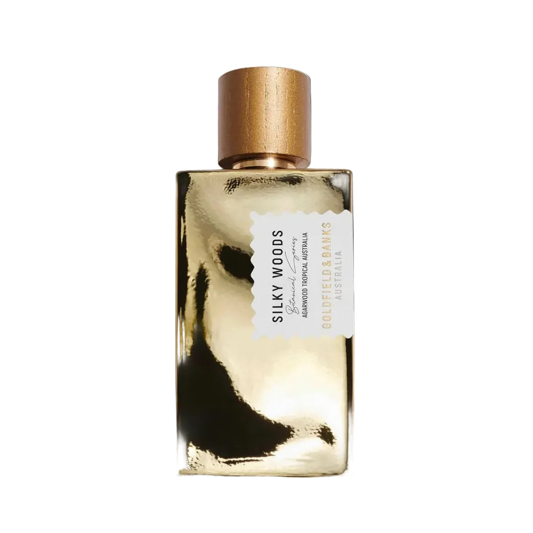 Gold perfume bottle with 'Silky Woods' label on a white background
