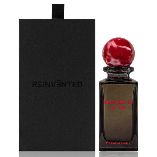 Perfume bottle with red cap and black label next to a black box labeled 'REINVENTED' on a white background