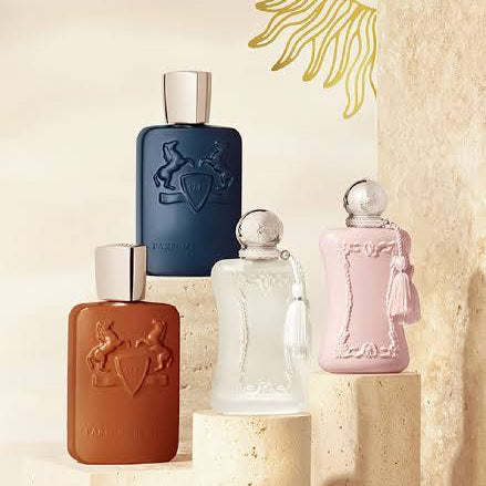 Set of five perfume bottles in different colors on a neutral background