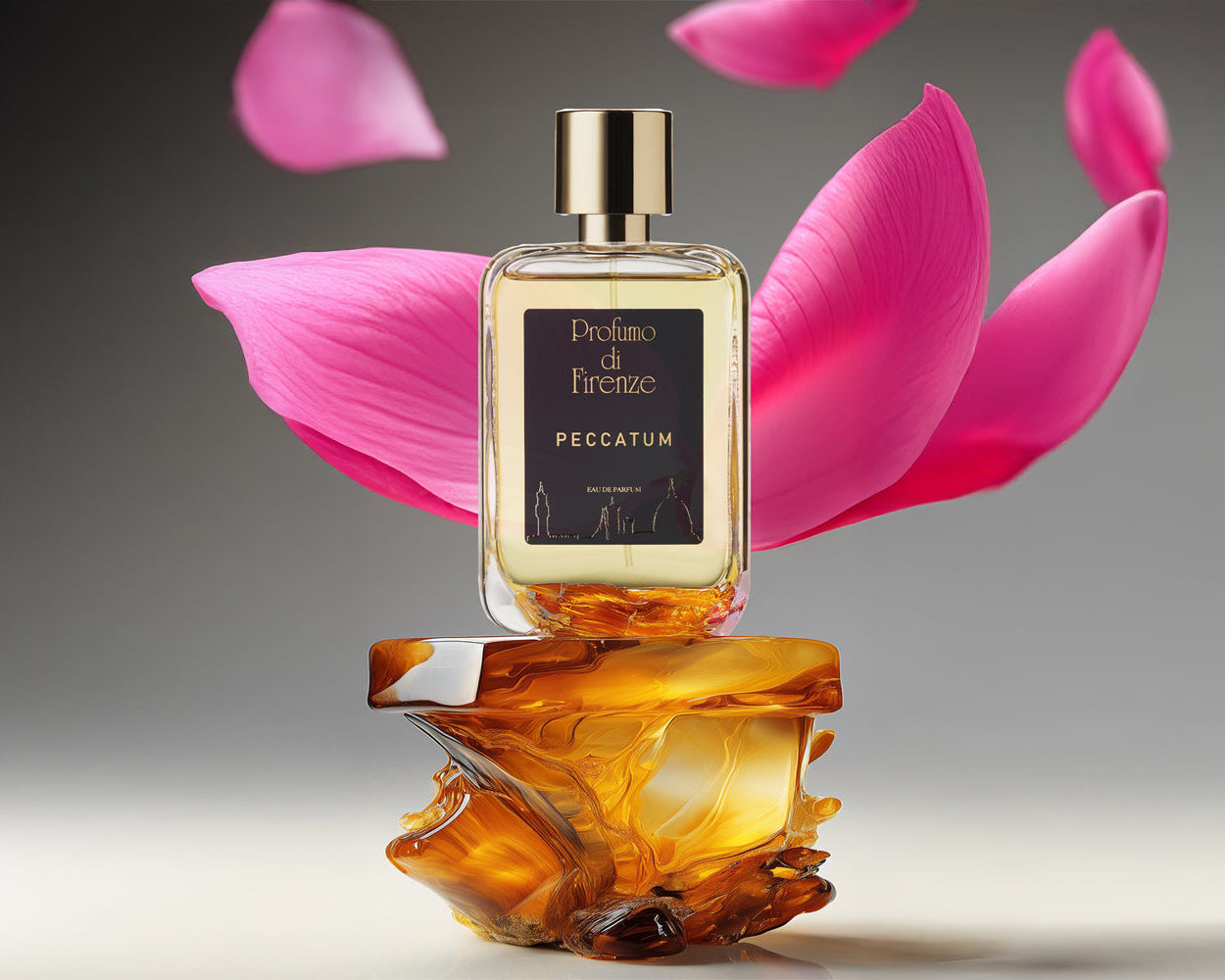 Perfume bottle with pink petals on a gray background