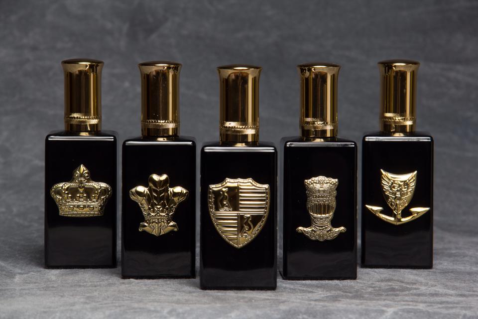 Set of black perfume bottles with gold accents on a gray background