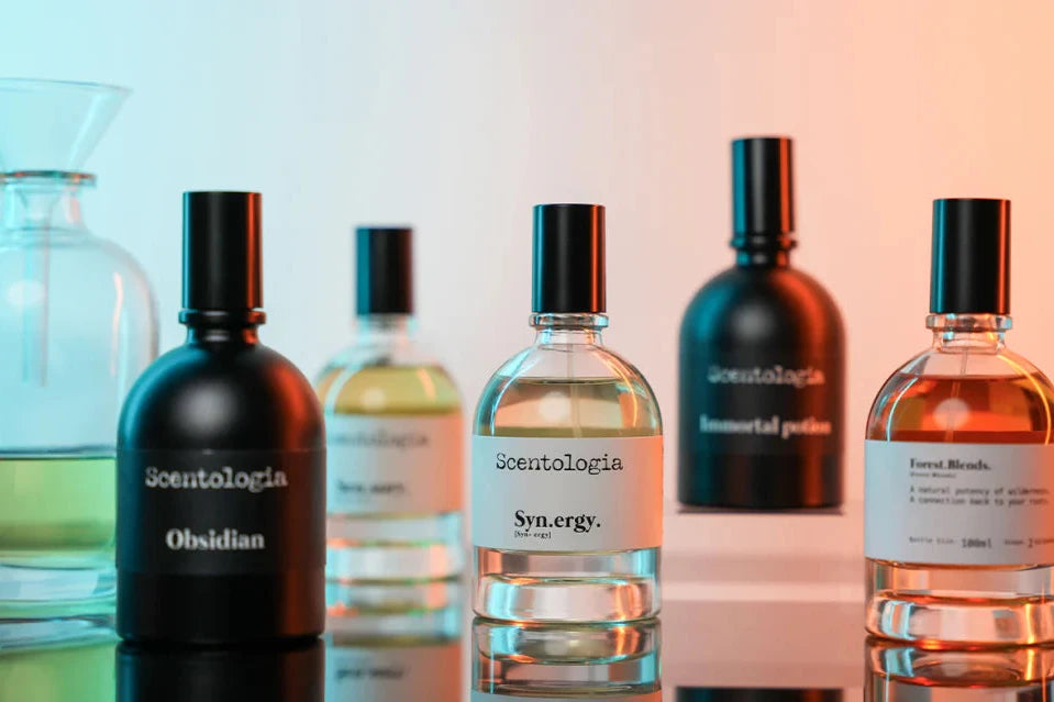 Collection of perfume bottles with labels on a gradient background