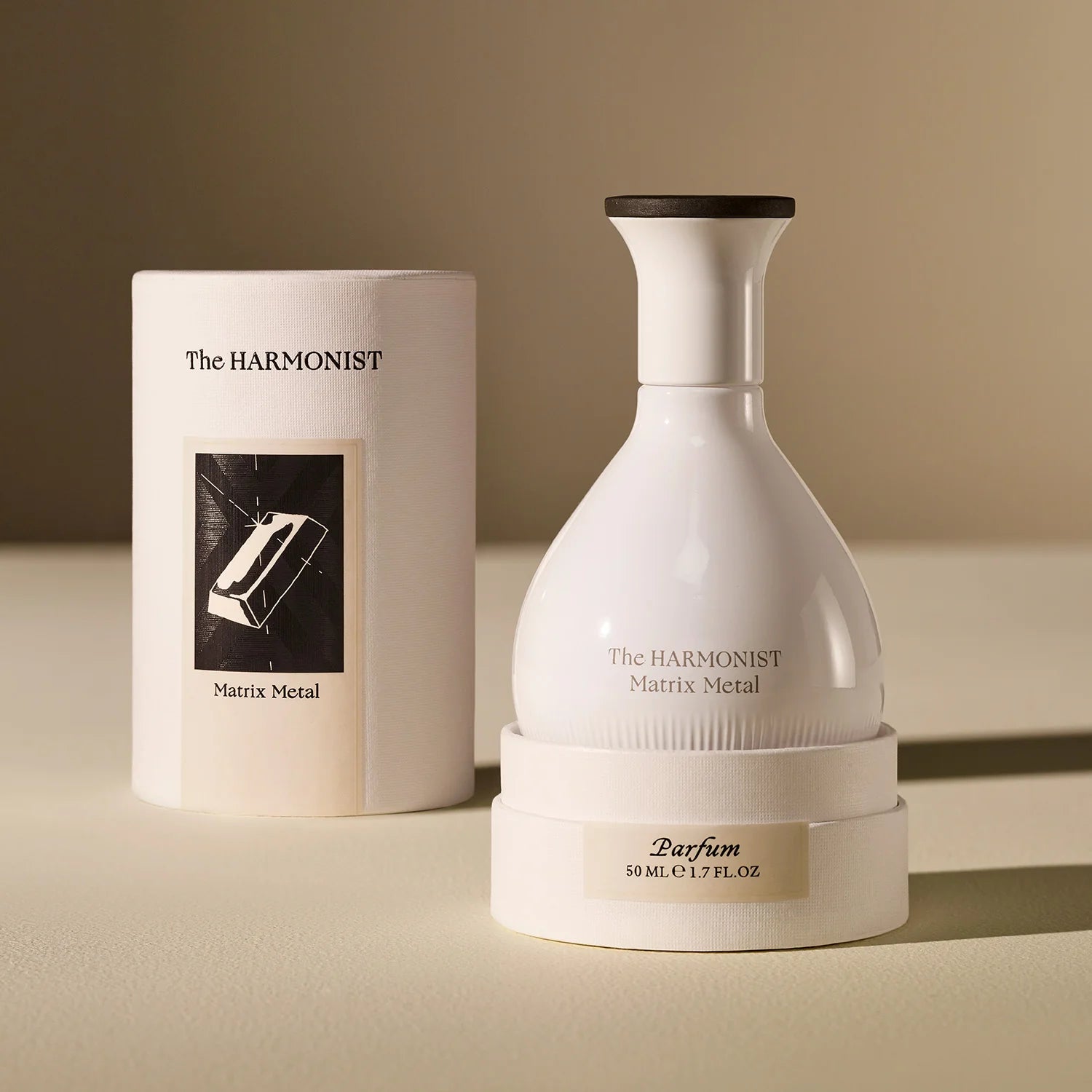 White perfume bottle and packaging of 'The Harmonist' on a beige background