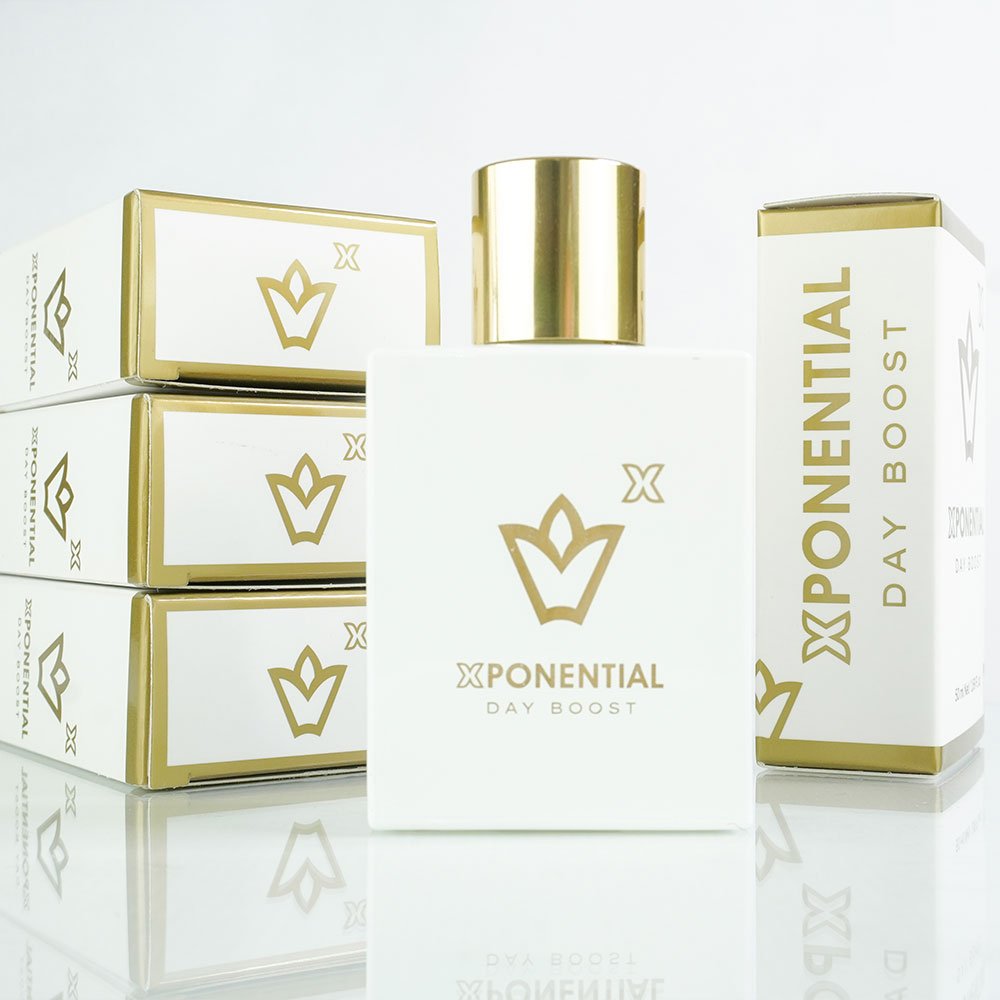 A bottle of Xponential Day Boost perfume with a white label and gold accents, displayed alongside stacked boxes with the product name and branding.
